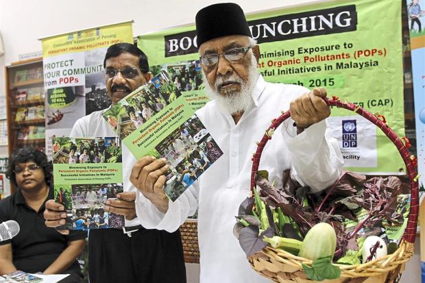 Helping the public: Mohamed Idris (right) with CAP education officer N.V. Subbarow launching the ‘Minimising Exposure to Persistent Organic Pollutants (POPs): Successful Initiatives in Malaysia’ book at their office in Jalan Masjid Negeri.